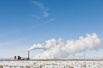 Complejo industrial y paisaje nevado bajo el cielo azul en Utah, EE.UU. - foto de stock