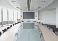 Televisão e grande mesa com reflexão na moderna sala de conferências — Fotografia de Stock