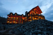 Grande hotel de madeira à noite com iluminação, vista de baixo ângulo — Fotografia de Stock