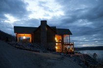 Hotel no campo com vista para o lago à noite — Fotografia de Stock