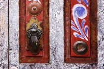 Close-up of rustic door with vintage handle and painting — Stock Photo
