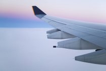 Ala e motores de aviões a jato em voo ao amanhecer — Fotografia de Stock