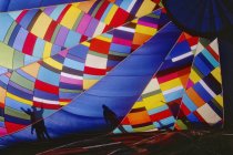 Inflando coloridos globos de aire caliente y siluetas de personas en Texas, EE.UU. - foto de stock