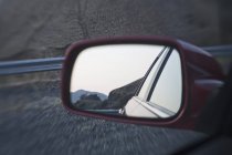 Parte de trás do carro no espelho com reflexão paisagem rural — Fotografia de Stock