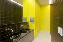 Zeitgenössische Toilette mit stilvollen schwarzen Fliesen und gelben Wänden — Stockfoto