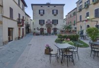 Medieval square with table and chairs in Pienza, Tuscany, Italy — Stock Photo