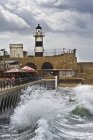 Fenced-in lighthouse in Acre cityscape with ancient wall, Israel — Stock Photo