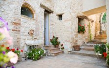 House and courtyard with flowering plants in pots — Stock Photo