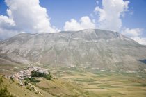 Bergstadt mit Bergen in der Ferne in Italien — Stockfoto