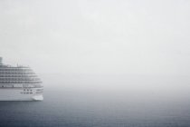 White luxury cruise ship in fog on ocean water — Stock Photo