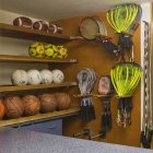 Sports equipment display with balls and rackets on wall — Stock Photo