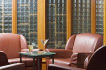 Sitzecke Stühle und Tisch mit Getränken im modernen Appartement-Interieur — Stockfoto