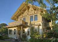 Gelbe Hausfassade mit Gartenvegetation — Stockfoto