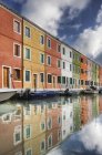 Casas coloridas y barcos en el agua en Venecia, Italia - foto de stock