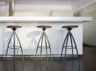 Trio of barstools in luxury highrise apartment — Stock Photo