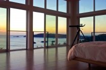 Telescopio en dormitorio con vista al mar en Oregon, EE.UU. - foto de stock