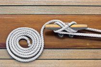 Rope and cleat on wooden table, close-up — Stock Photo