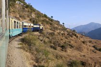 Train voyageant à travers la campagne à Dharampur, Himachal Pradesh, Inde — Photo de stock
