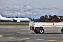 Rimorchio bagagli sull'asfalto dell'aeroporto di Seattle, Washington, USA — Foto stock