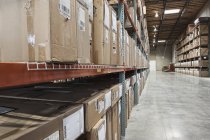 Картонные коробки на полках на складе — стоковое фото