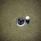Gros plan de la balle de golf à côté de la tasse — Photo de stock