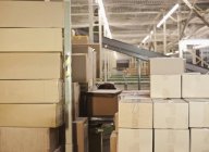 Boîtes en carton empilées dans un entrepôt industriel — Photo de stock