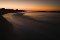 Curvy beach water and sand at sunset, Virginia, USA — Stock Photo