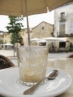 Close-up of empty glass on saucer at street cafe table in Besalu, Spain — Stock Photo