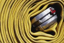 Coiled yellow fire hose, close-up — Stock Photo