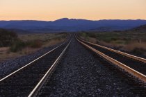 Linhas ferroviárias ao amanhecer com montanhas à distância, Texas, EUA — Fotografia de Stock