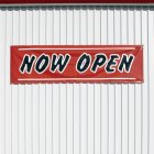 Now Open sign hanging on wall in Bradenton, Florida, USA — Stock Photo