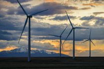 Turbinas eólicas ao pôr-do-sol com nuvens no céu dramático, Colorado, EUA — Fotografia de Stock