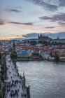 Touristen auf der Karlsbrücke und der Prager Burg im Stadtbild bei Sonnenuntergang, Prag, Tschechische Republik — Stockfoto