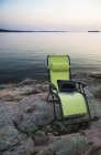 Portatile su sedia a sdraio vicino al fiume remoto, Canada — Foto stock