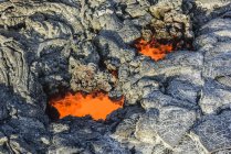 Geschmolzene Lava glüht in der Nähe getrockneter Lava auf Felsen der großen Insel, Hawaii, USA — Stockfoto
