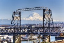 Snowy mountain viewed through urban bridge, Tacoma, Washington, United States — Stock Photo