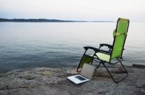Laptop auf Rasenstuhl in der Nähe eines entlegenen Flusses, Kanada — Stockfoto