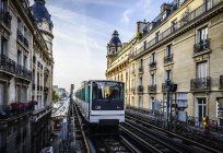 Tranvía que pasa entre edificios de apartamentos, París, Francia - foto de stock