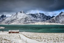 Snowy mountains overlooking ocean, Reine, Lofoten Islands, Norway — Stock Photo