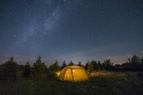 Barraca de acampamento iluminada sob céu estrelado — Fotografia de Stock
