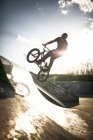 Hombre caucásico montando BMX bicicleta en skate park - foto de stock