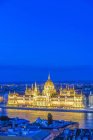 Vista aérea del edificio del Parlamento iluminado al atardecer en el paisaje urbano de Budapest, Hungría - foto de stock