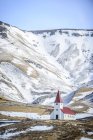 Chiesa sotto le montagne innevate nel paesaggio rurale, Vik i Myrdal, Islanda — Foto stock