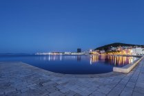 Gehweg am Wasser, beleuchtete Boote und Anlegestelle in der Dämmerung, Split, Kroatien — Stockfoto
