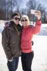 Joven pareja caucásica tomando selfie en invierno - foto de stock