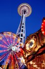 Vista ad angolo basso di Space Needle, ruota panoramica e giostra sotto il cielo notturno, Seattle, Washington, Stati Uniti — Foto stock