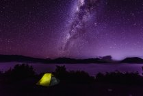 Milky Way galaxy over campsite in starry night sky — Stock Photo