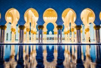 Arcos ornamentados azulejos da Grande Mesquita iluminando à noite, Abu Dhabi, Emirados Árabes Unidos — Fotografia de Stock
