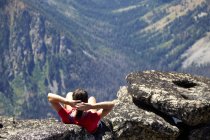 Randonneur assis sur une colline rocheuse, Washington, États-Unis — Photo de stock