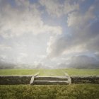Rock wall and staircase under clouds in rural landscape — Stock Photo